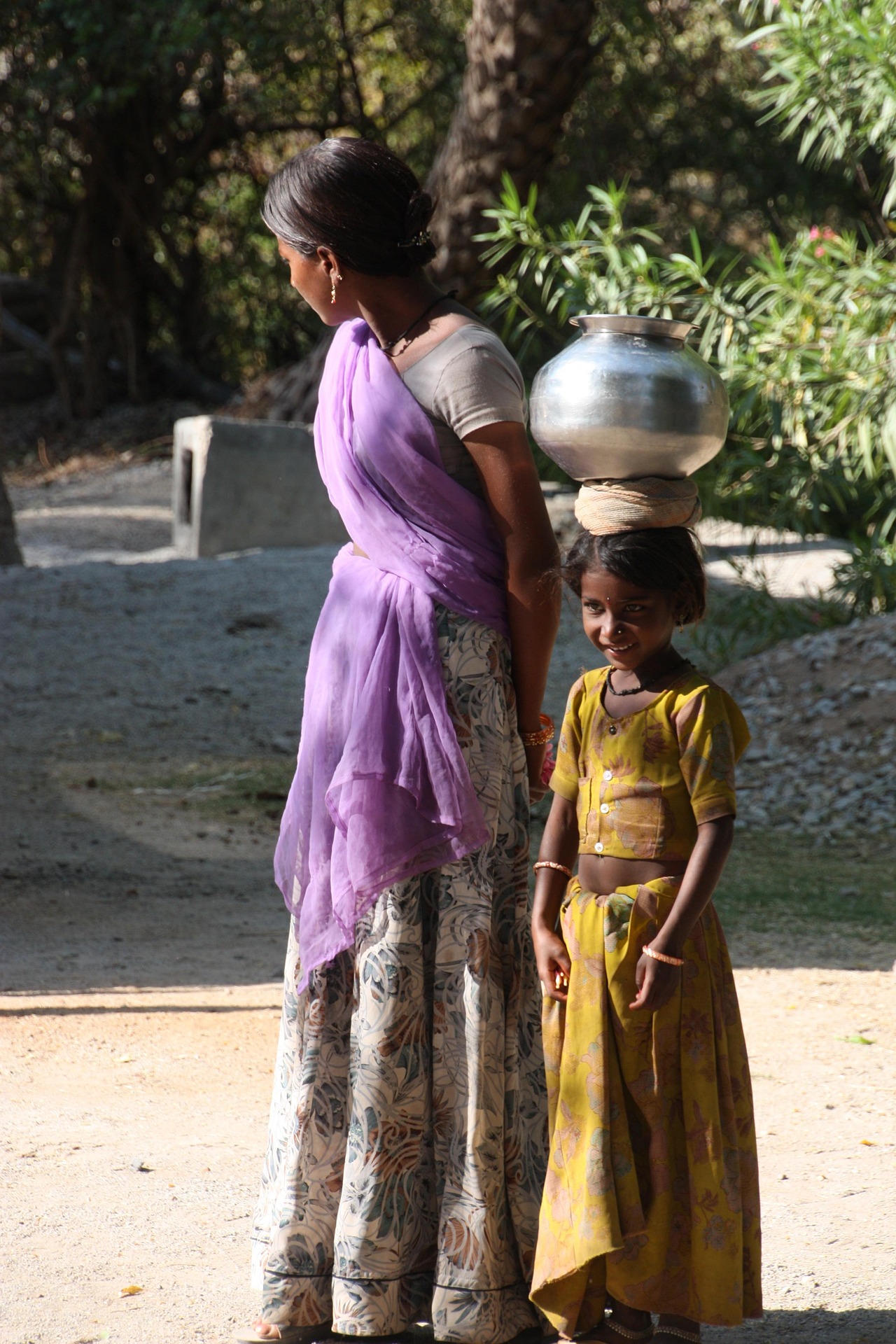 A mother and child walking together through their village community