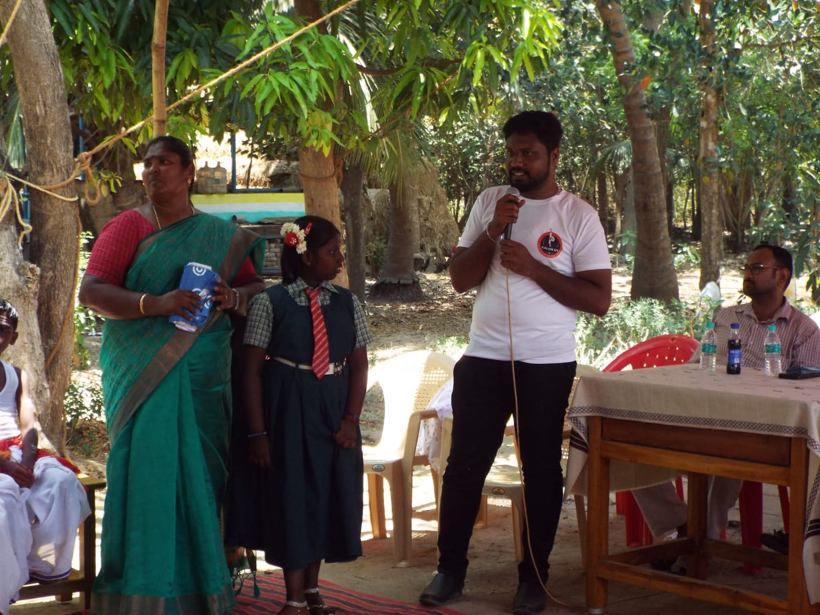 A young volunteer supporting a community member during a field visit